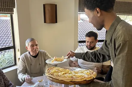 Convidados sendo servidos à mesa durante o aniversário