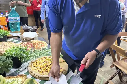Colaborador se servindo na estação de pizza