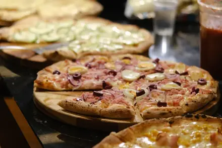 Várias pizzas do rodízio na bancada montada no local do evento, de onde cada convidado se serve