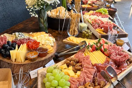 Mesa de frios da recepção, com flores e tábuas em fila