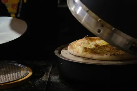 Pizza saindo do forno na estação montada no evento