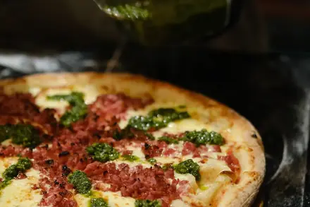 Pizza de calabresa com pesto na tábua
