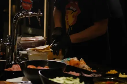 Pizzaiolo da BeatOven cortando a pizza na bancada