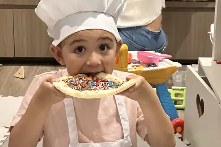 Criança mostrando a pizza doce que decorou