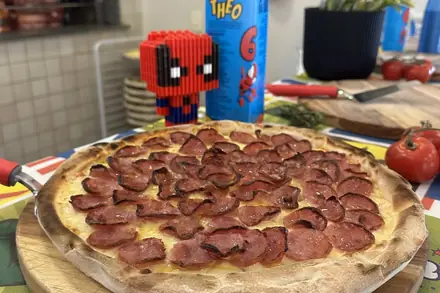 Pizza de calabresa na mesa decorada da festa infantil