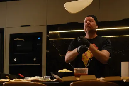 Pizzaiolo da BeatOven jogando a massa no ar durante a festa