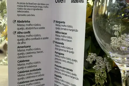 Cardápio impresso com o nome dos noivos e taças na mesa do casamento