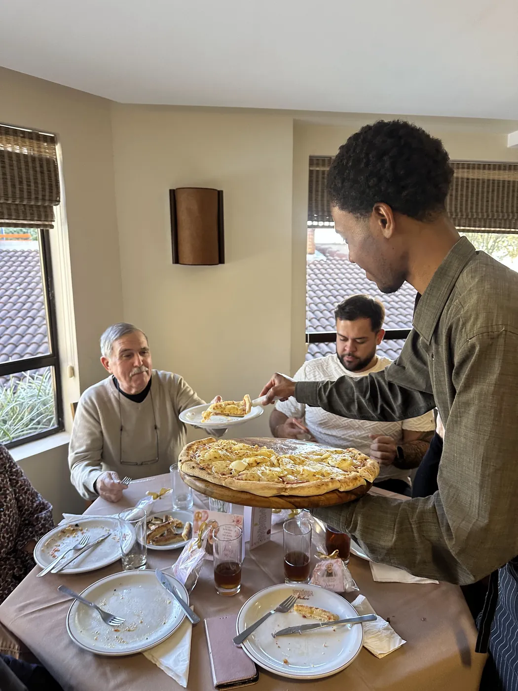 Convidados sendo servidos à mesa durante o aniversário