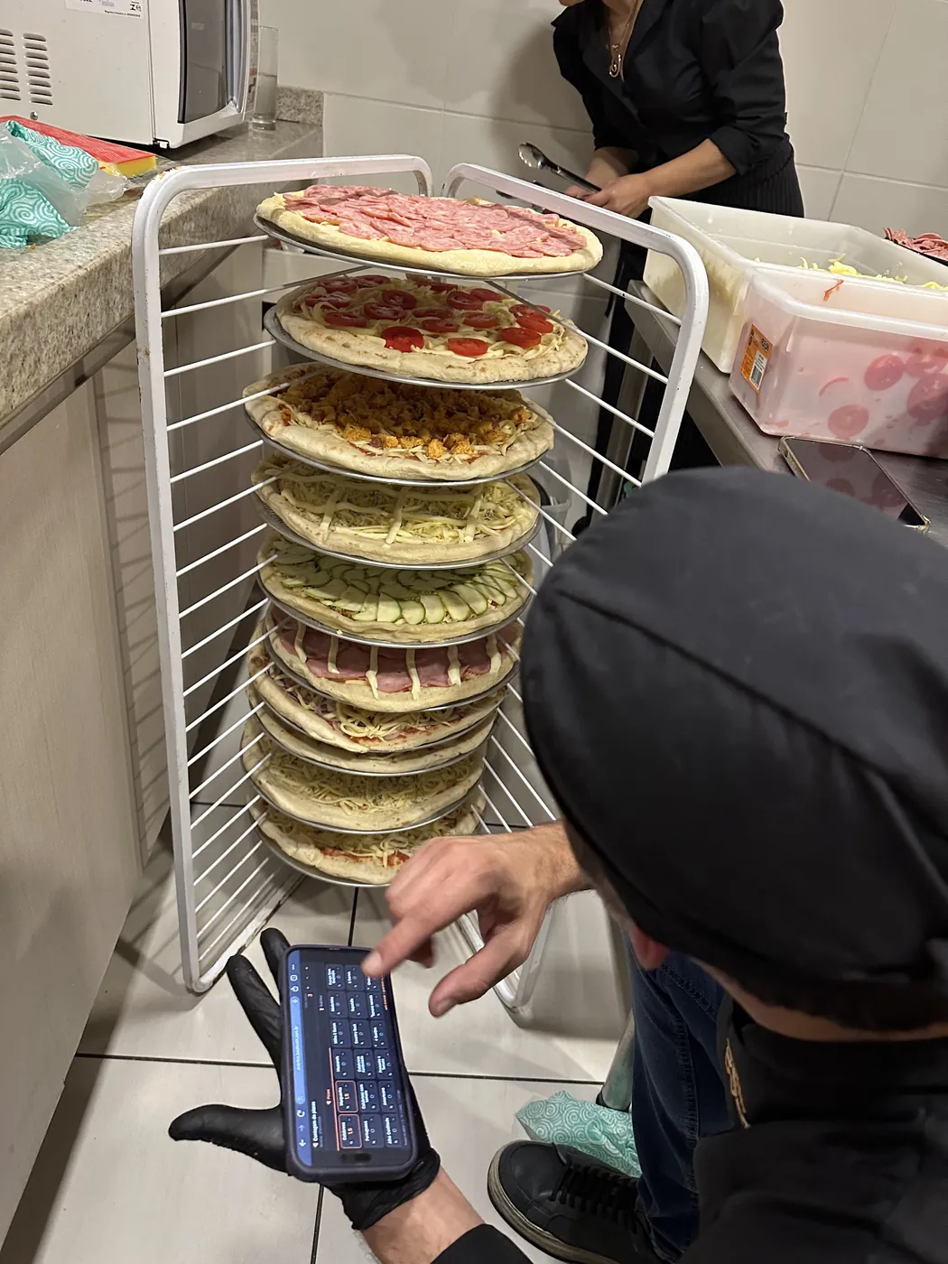 Carrinho com as pizzas montadas, prontas para o forno
