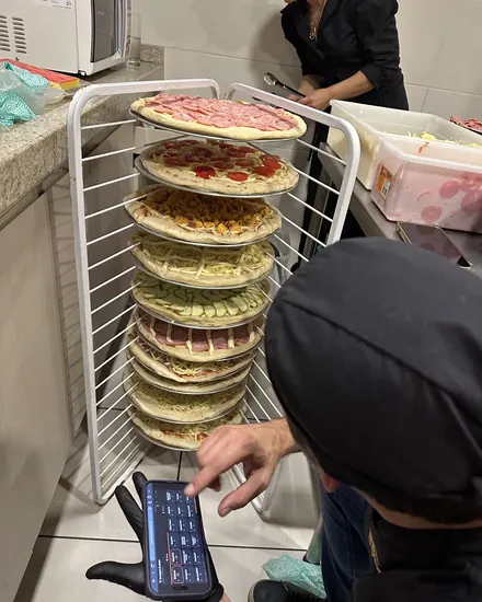 Carrinho com as pizzas montadas, prontas para o forno