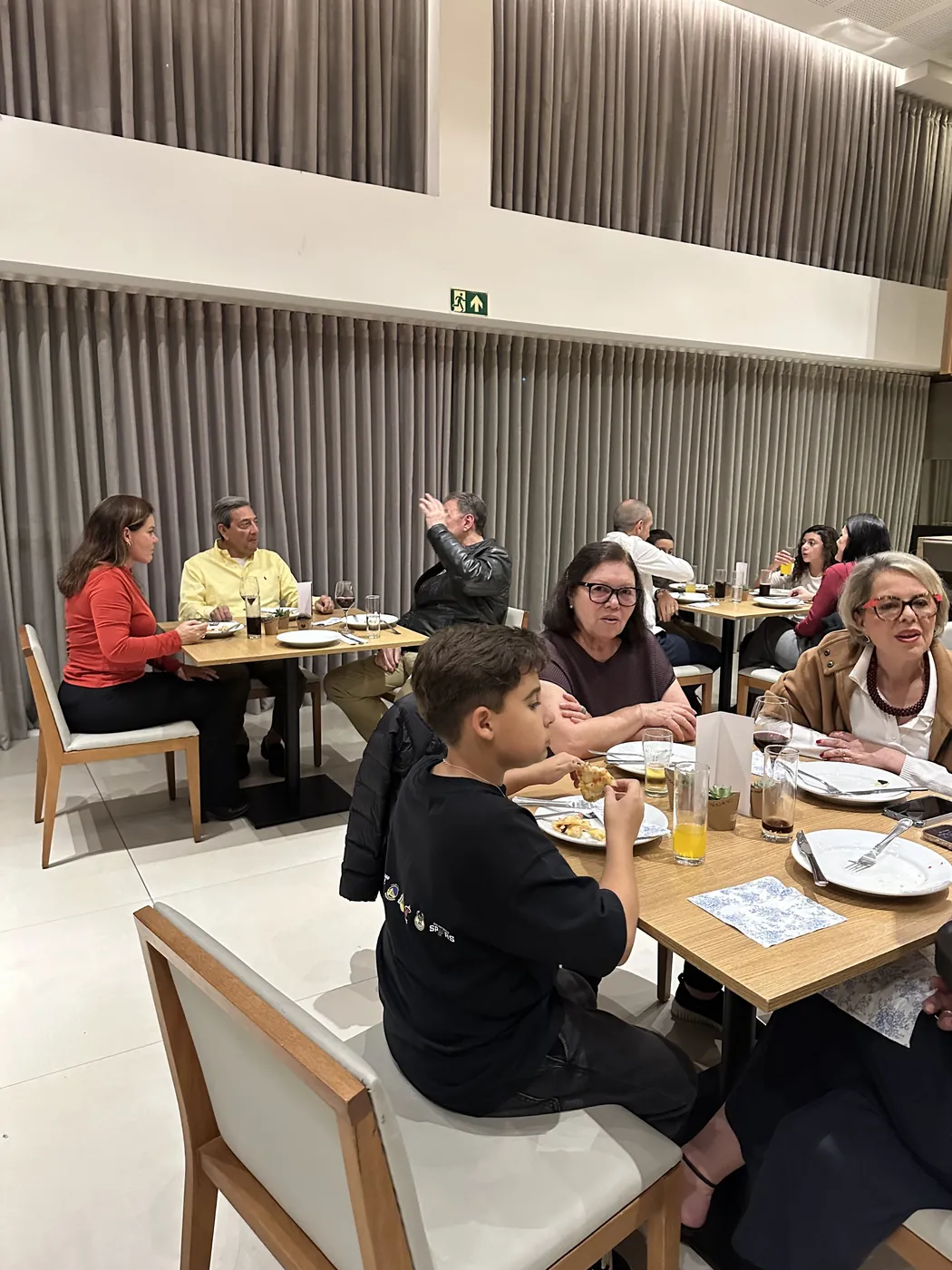 Convidados nas mesas durante a festa, com a pizza servida
