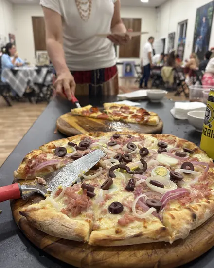 Pizza portuguesa na tábua, com a festa ao fundo