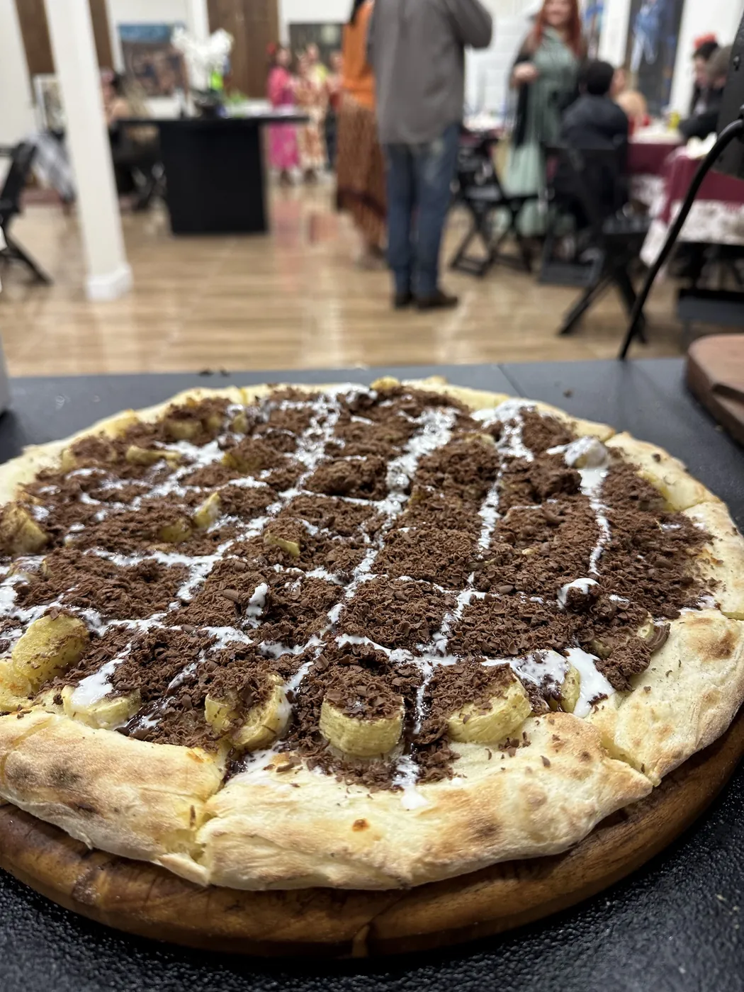 Pizza doce de chocolate com banana servida na festa