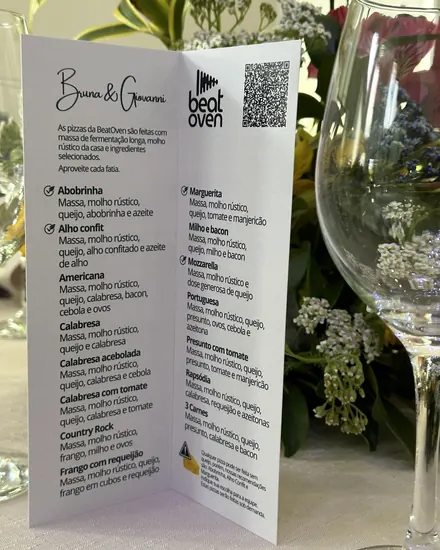 Cardápio impresso com o nome dos noivos na mesa do casamento