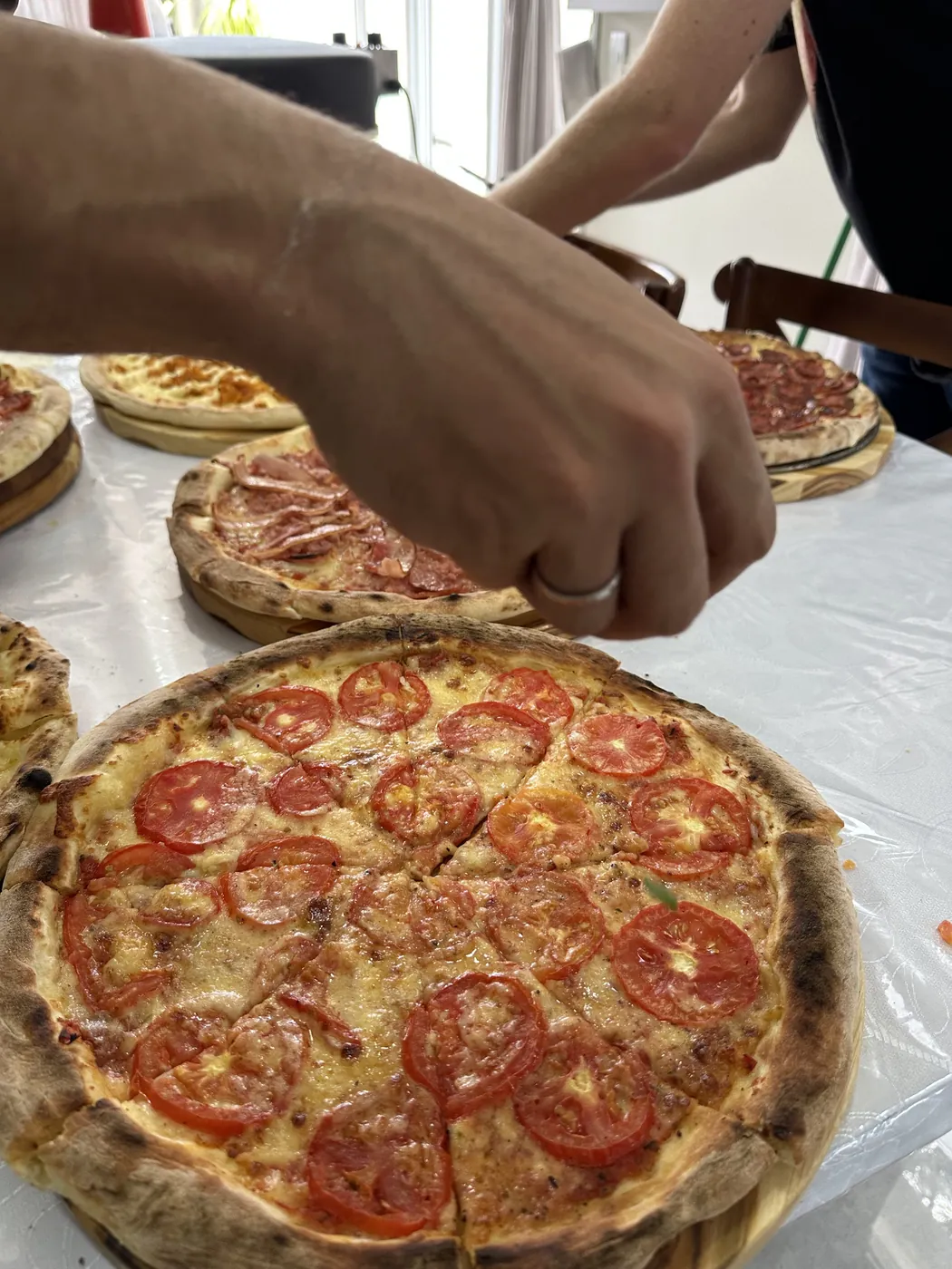 Pizza marguerita sendo cortada para servir