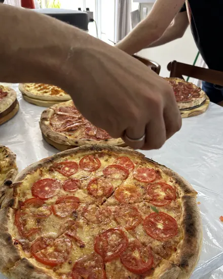 Pizza marguerita sendo cortada para servir