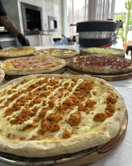 Pizzas prontas na bancada montada no local do casamento