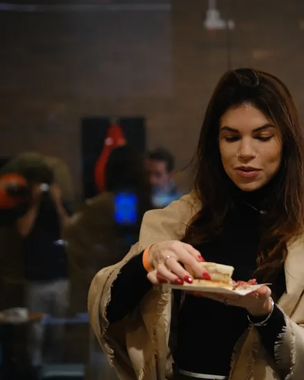 Convidada provando a pizza no evento corporativo