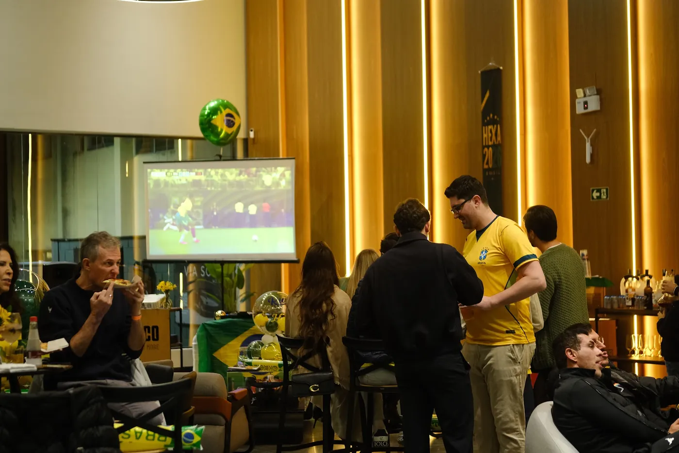 Convidados em volta da estação de pizza durante o evento