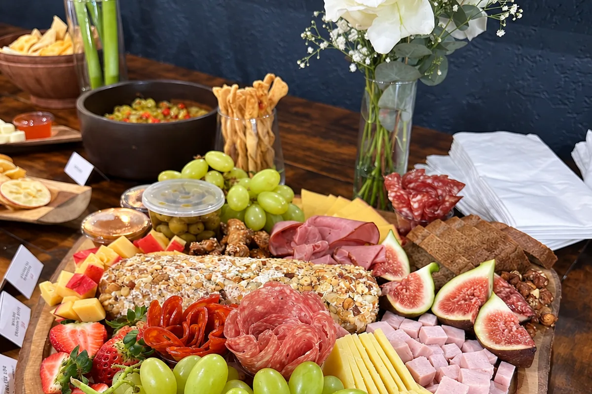 Mesa de frios com cheeselog, figos, uvas e queijos