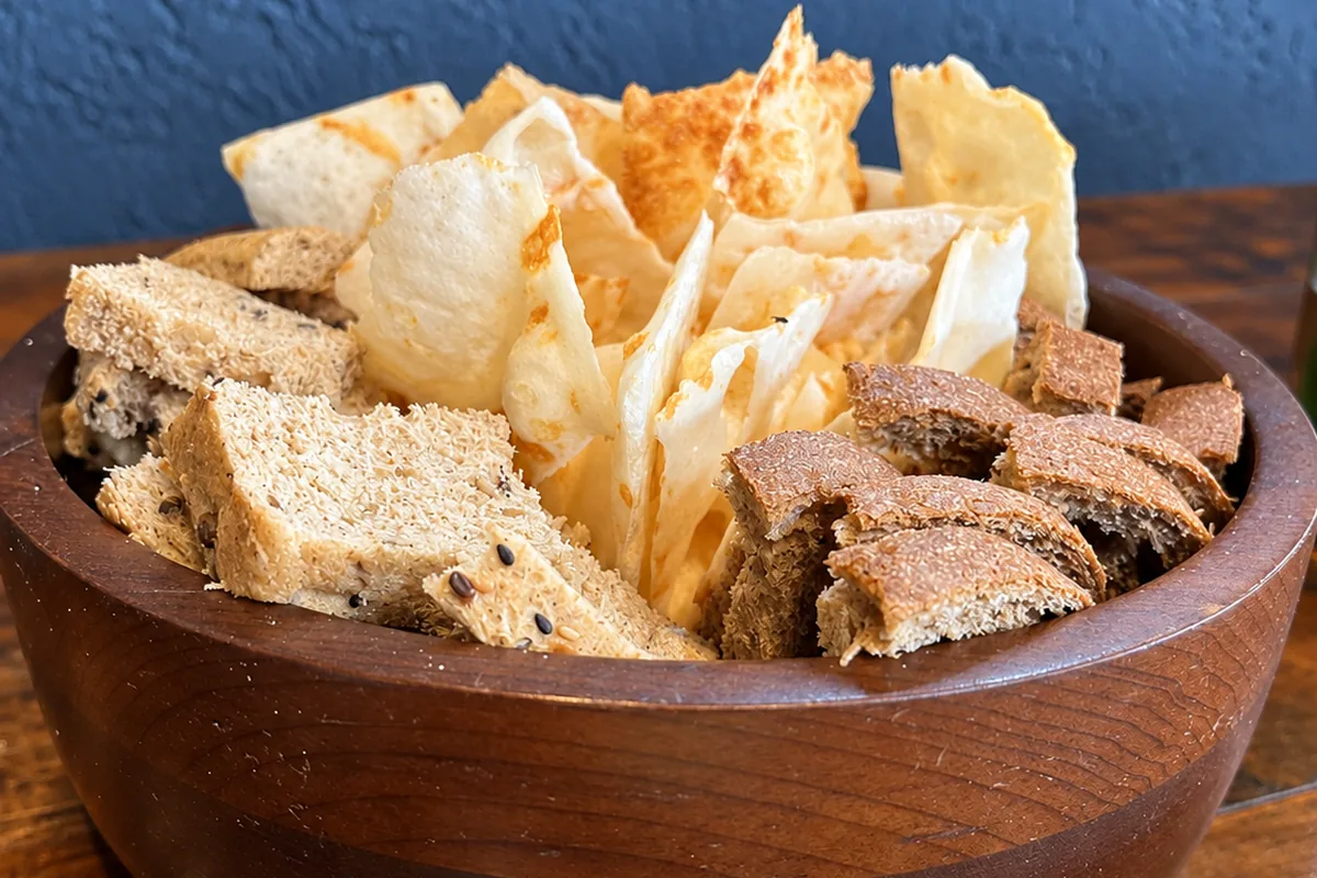 Pães e torradas servidos ao lado da mesa de frios