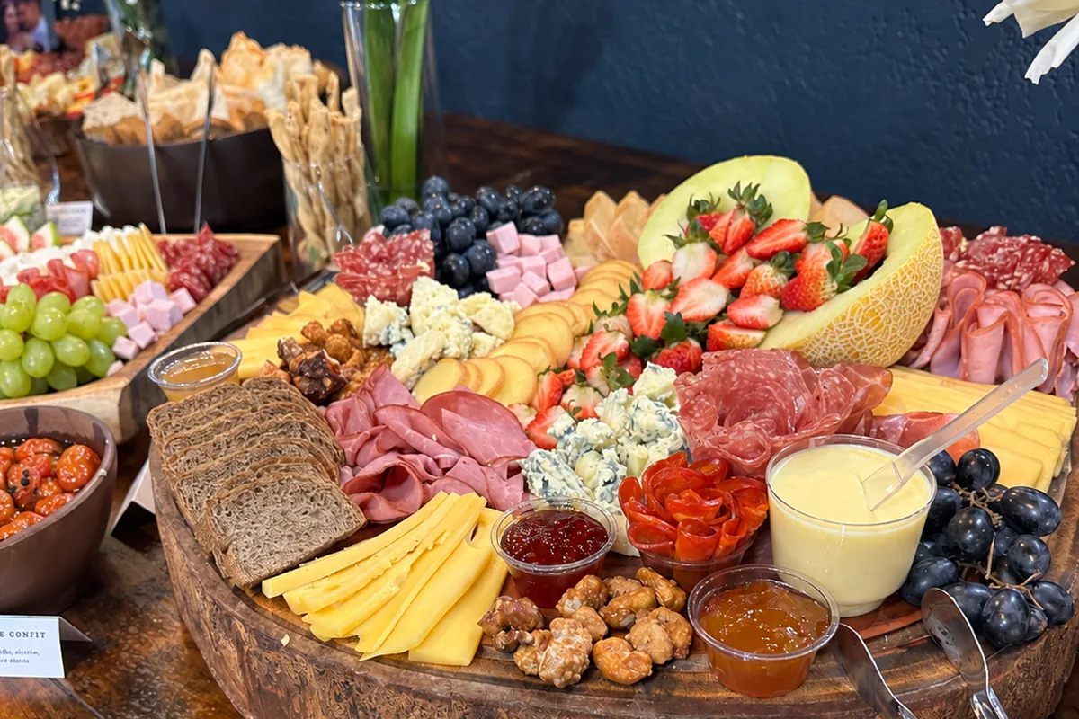 Mesa de frios montada com talheres e placas de identificação