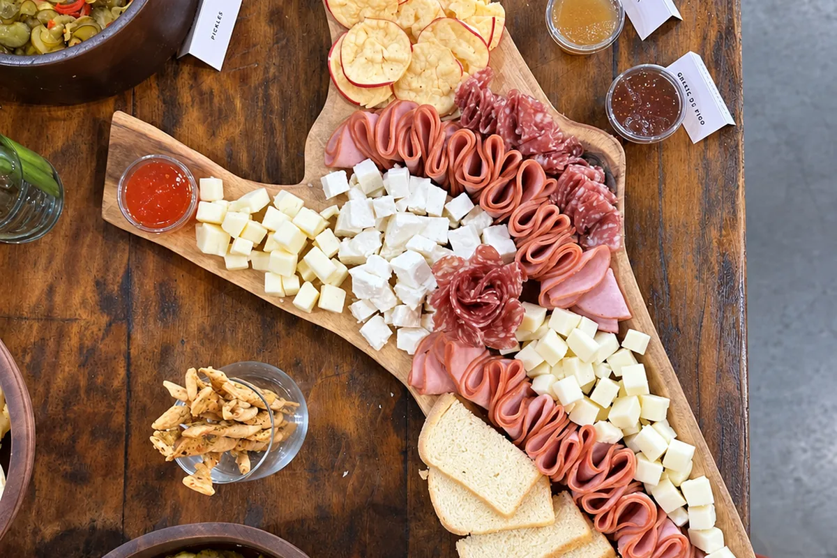 Tábua de frios na mesa, com patês, torradas e antepastos