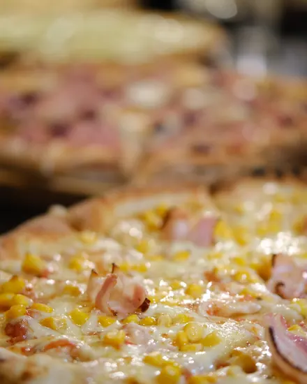 Pizza de milho com bacon saindo do forno