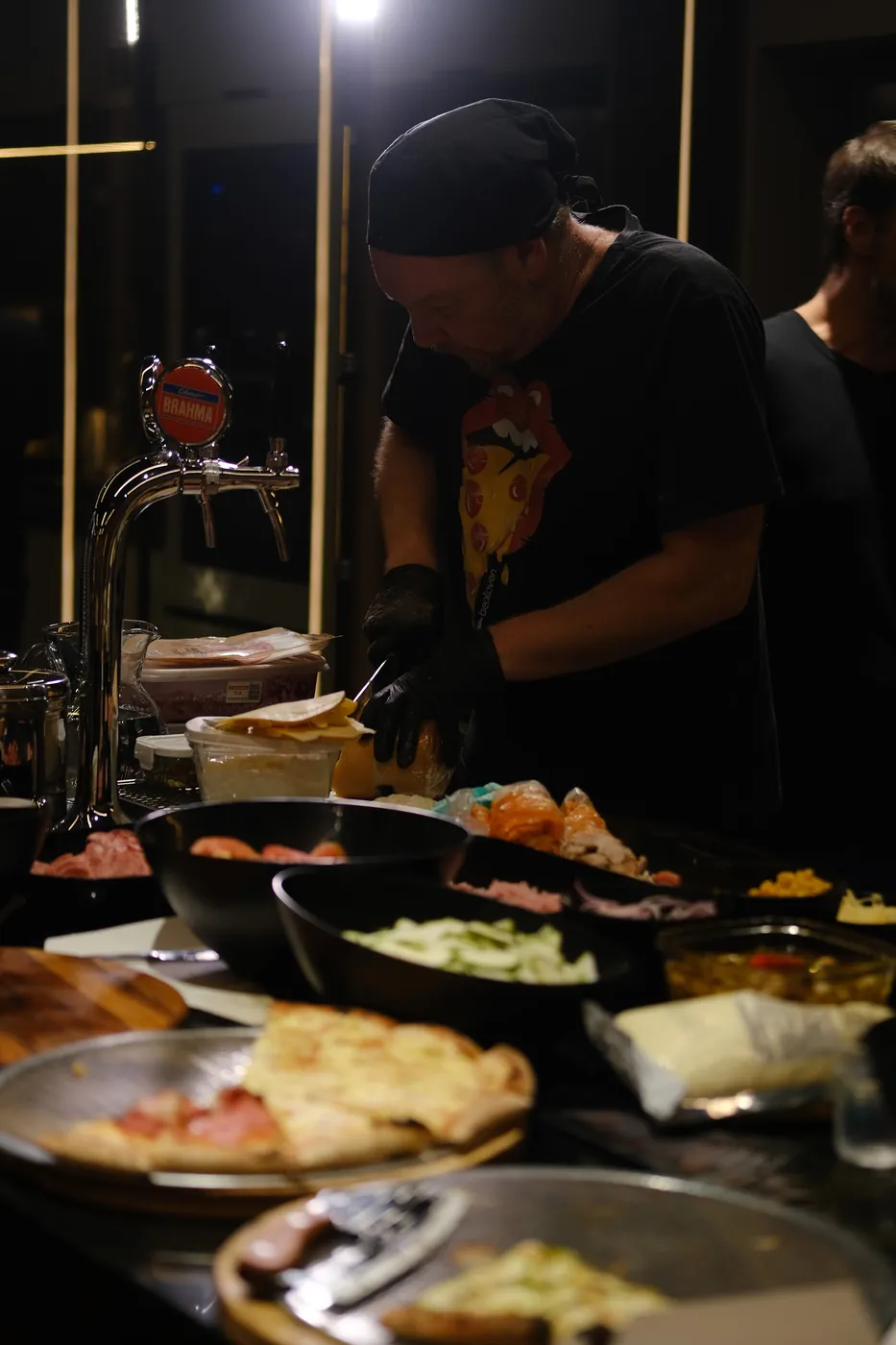 Pizzaiolo da BeatOven cortando a pizza na bancada