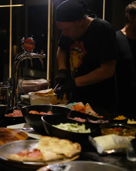 Pizzaiolo da BeatOven cortando a pizza na bancada