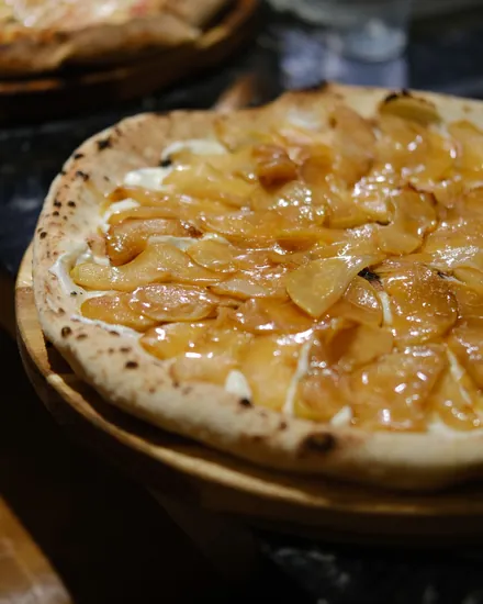 Pizza recém-assada na tábua de madeira, na bancada montada no evento