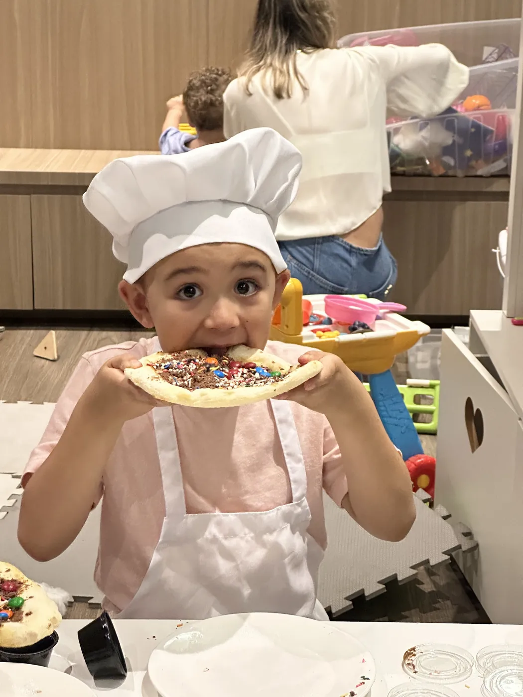 Criança mostrando a pizza doce que decorou