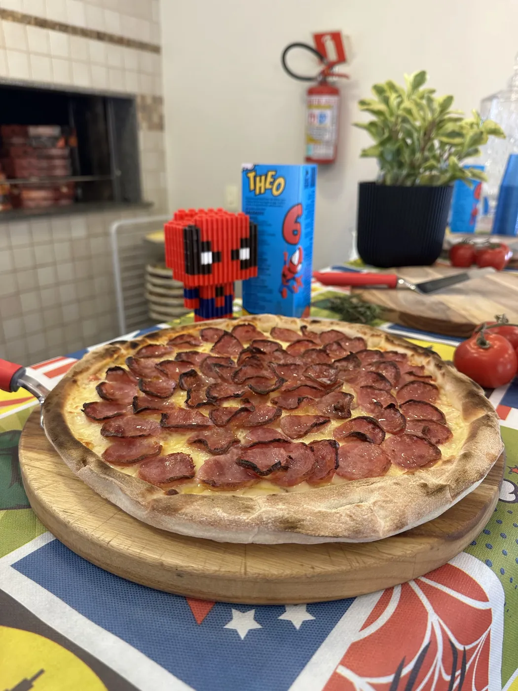 Pizza de calabresa na mesa decorada da festa infantil