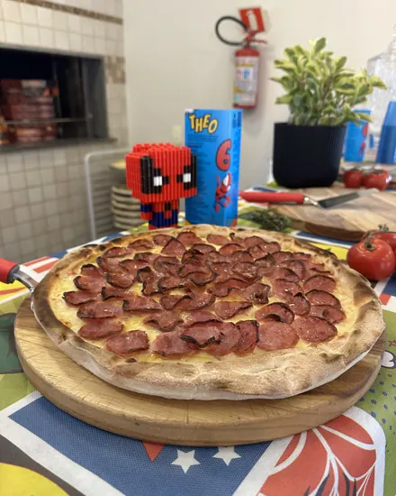 Pizza de calabresa na mesa decorada da festa infantil