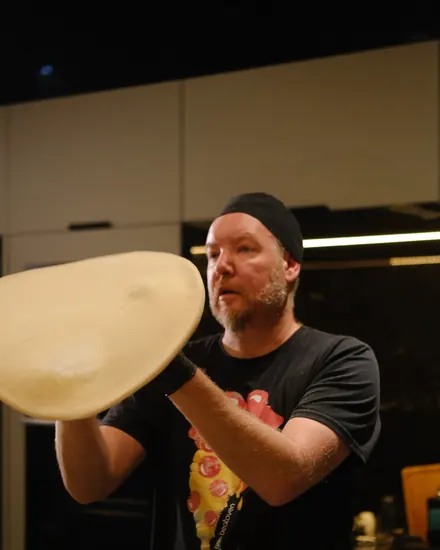 Pizzaiolo da BeatOven abrindo a massa no ar