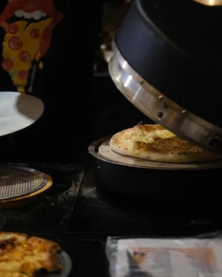 Pizza saindo do forno na estação montada no evento