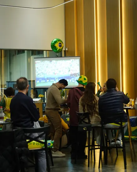 Convidados em volta da estação de pizza durante o evento