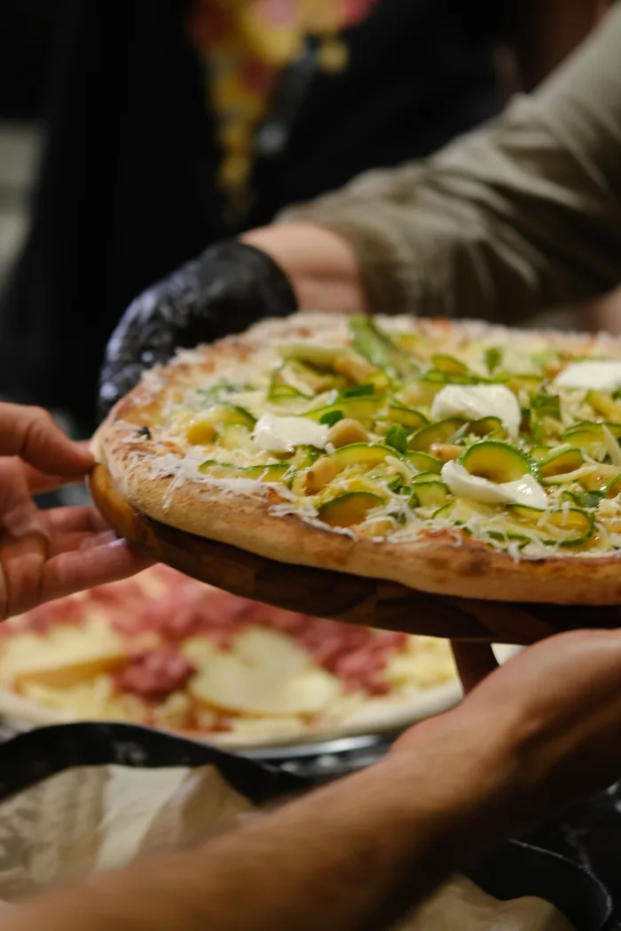 Pizza de abobrinha com burrata servida na tábua durante um evento da BeatOven