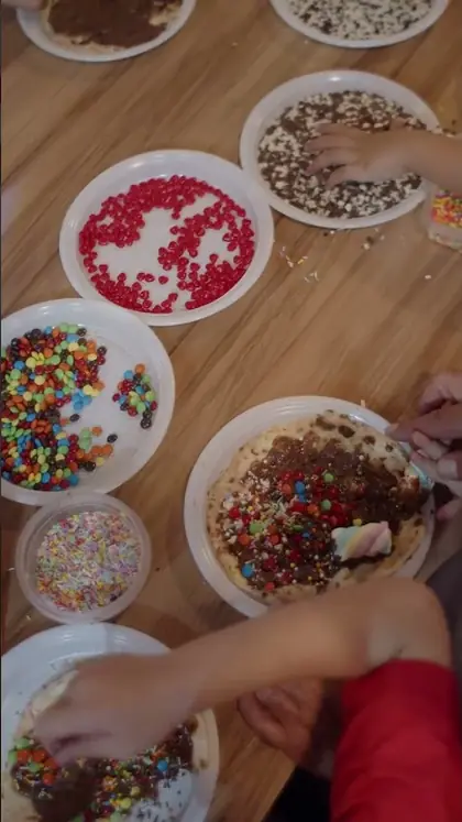 Mesa de confeitos e frutas para as crianças decorarem a pizza doce
