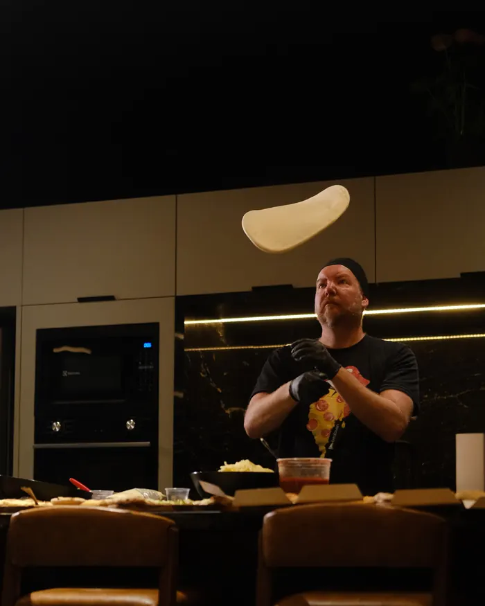 Pizzaiolo da BeatOven abrindo a massa no ar