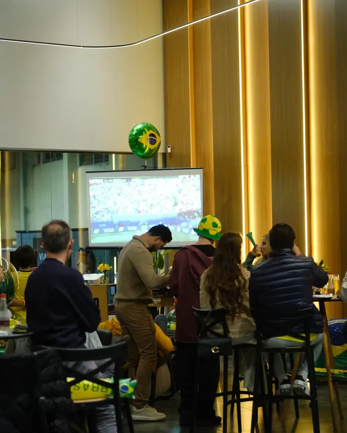 Convidados em volta da estação de pizza durante o evento