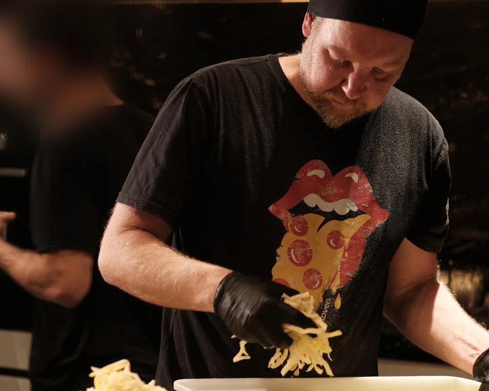 Pizzaiolo da BeatOven montando as pizzas no evento da Via Soho Motors