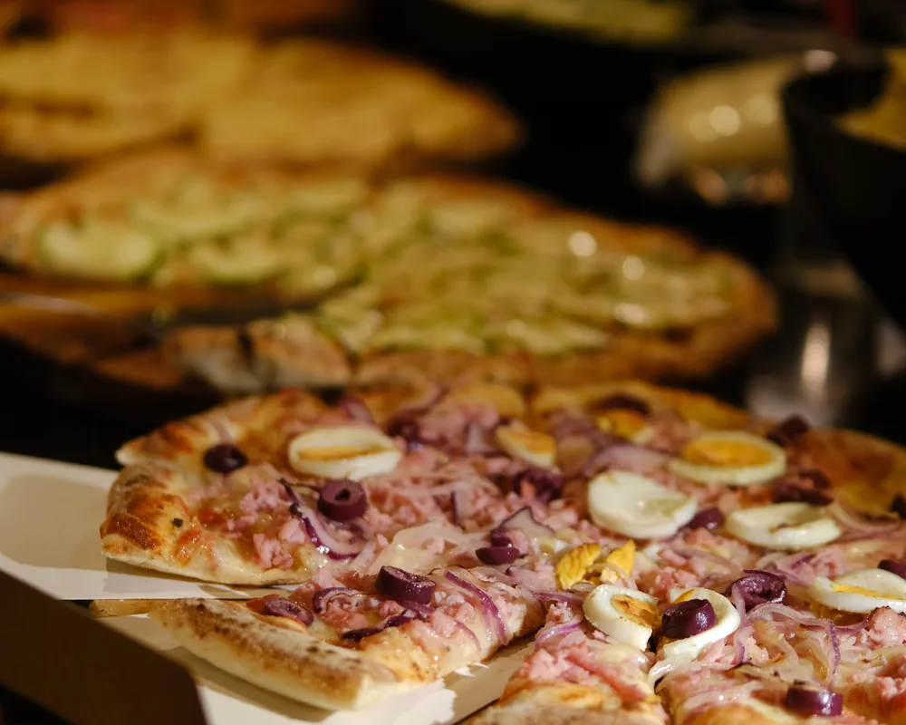 Pizzas saindo uma atrás da outra na bancada montada no evento